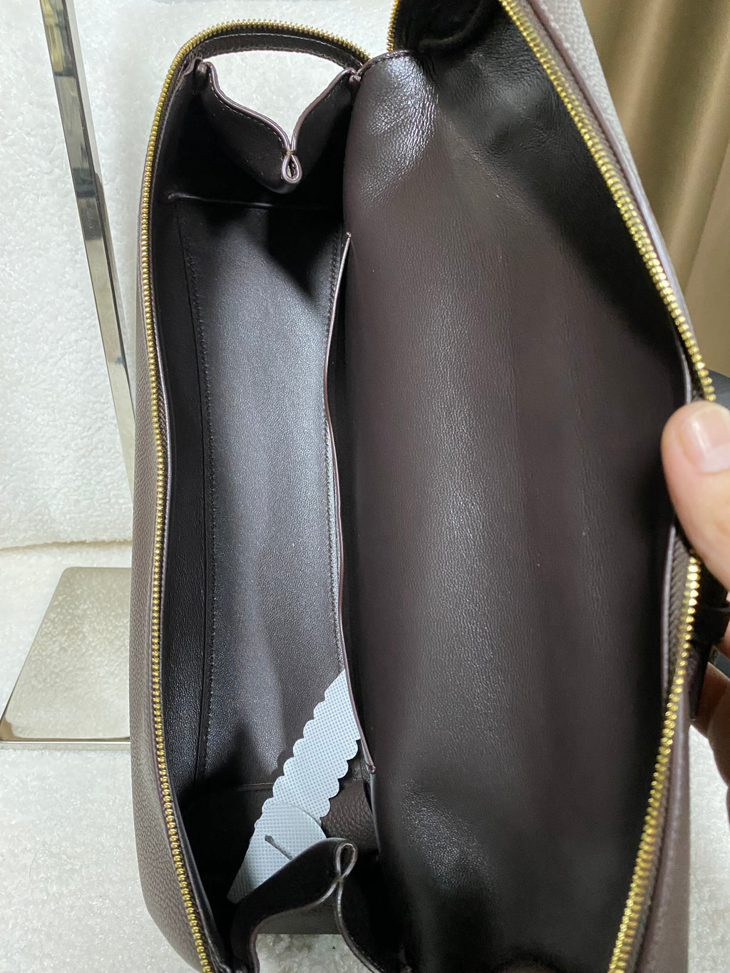 Open dark-lined interior of coffee brown leather shoulder bag