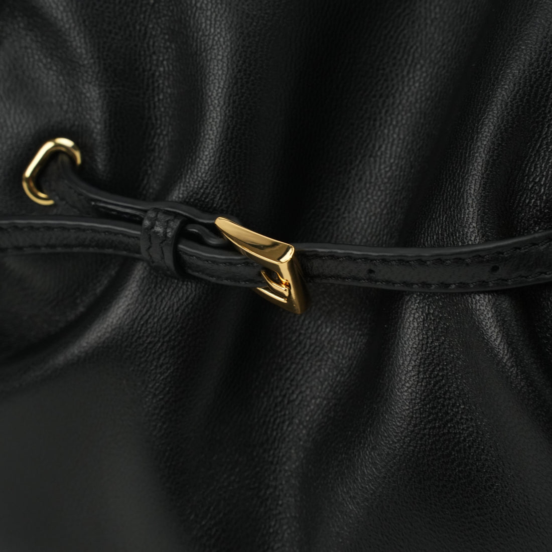Black ruched lambskin crossbody bag — gold drawstring hardware close-up