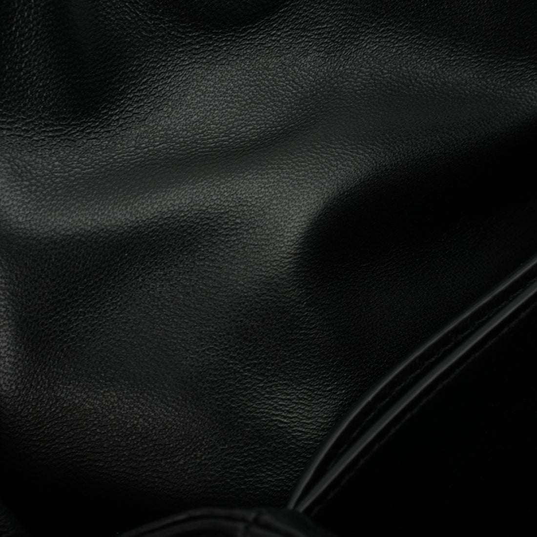 Black ruched lambskin crossbody bag — soft black lambskin texture close-up