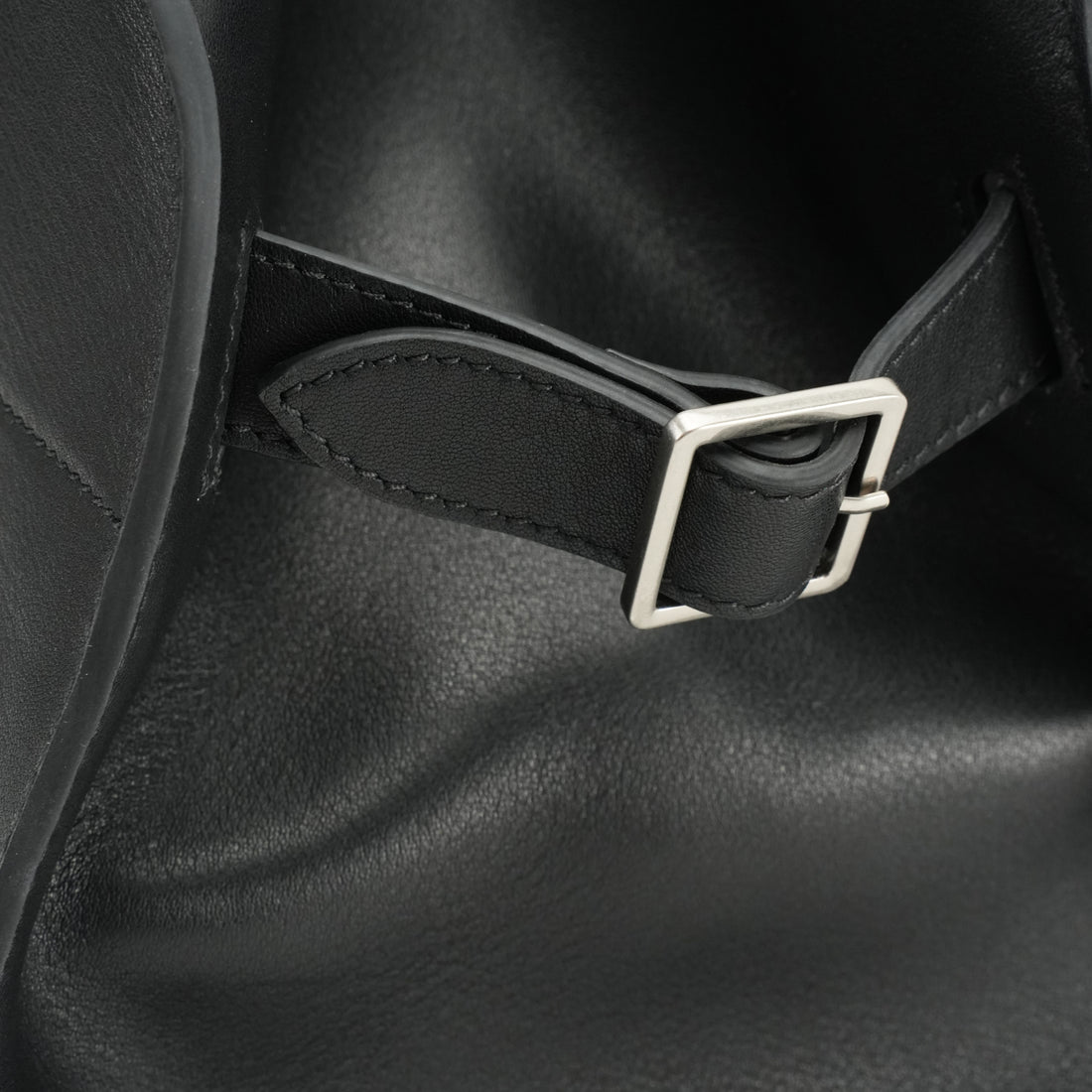 Logo-free black cowhide work tote — side buckle close-up