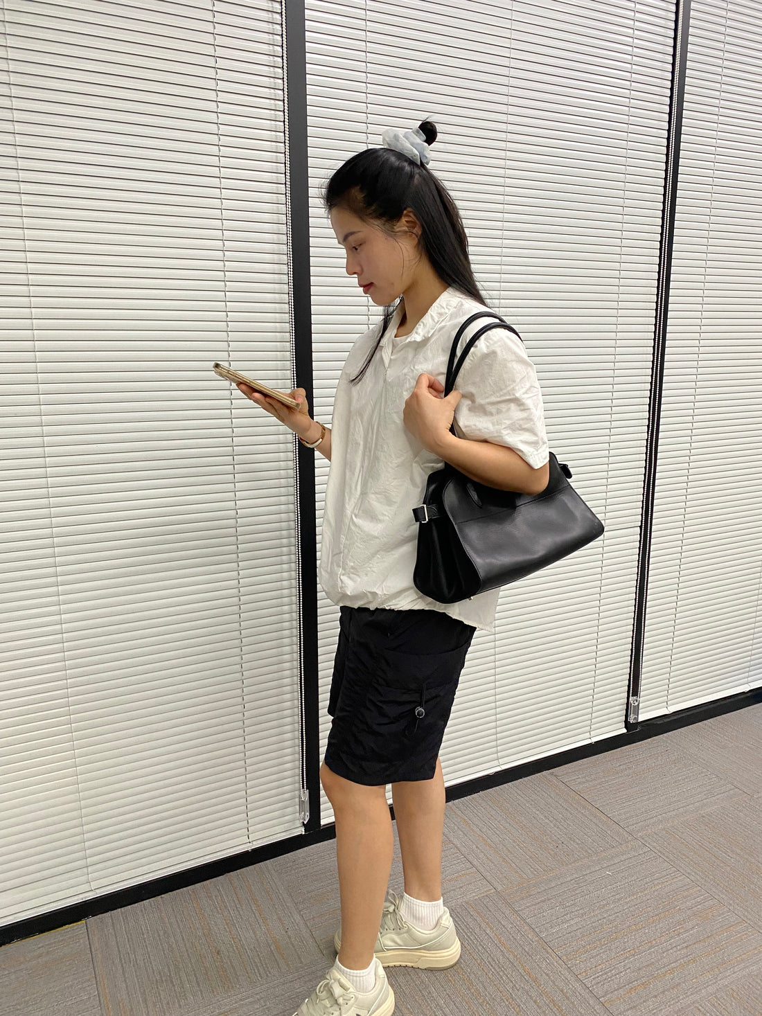 Logo-free black cowhide work tote — worn on the shoulder