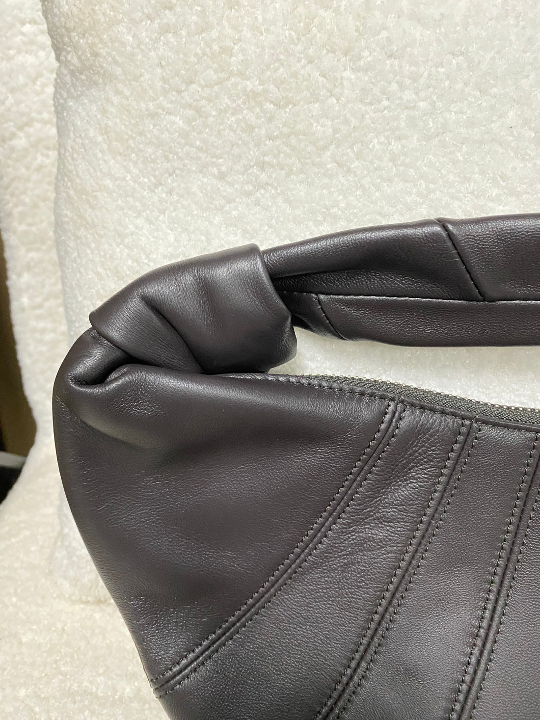 Pleated lambskin stitching and knotted handle close-up