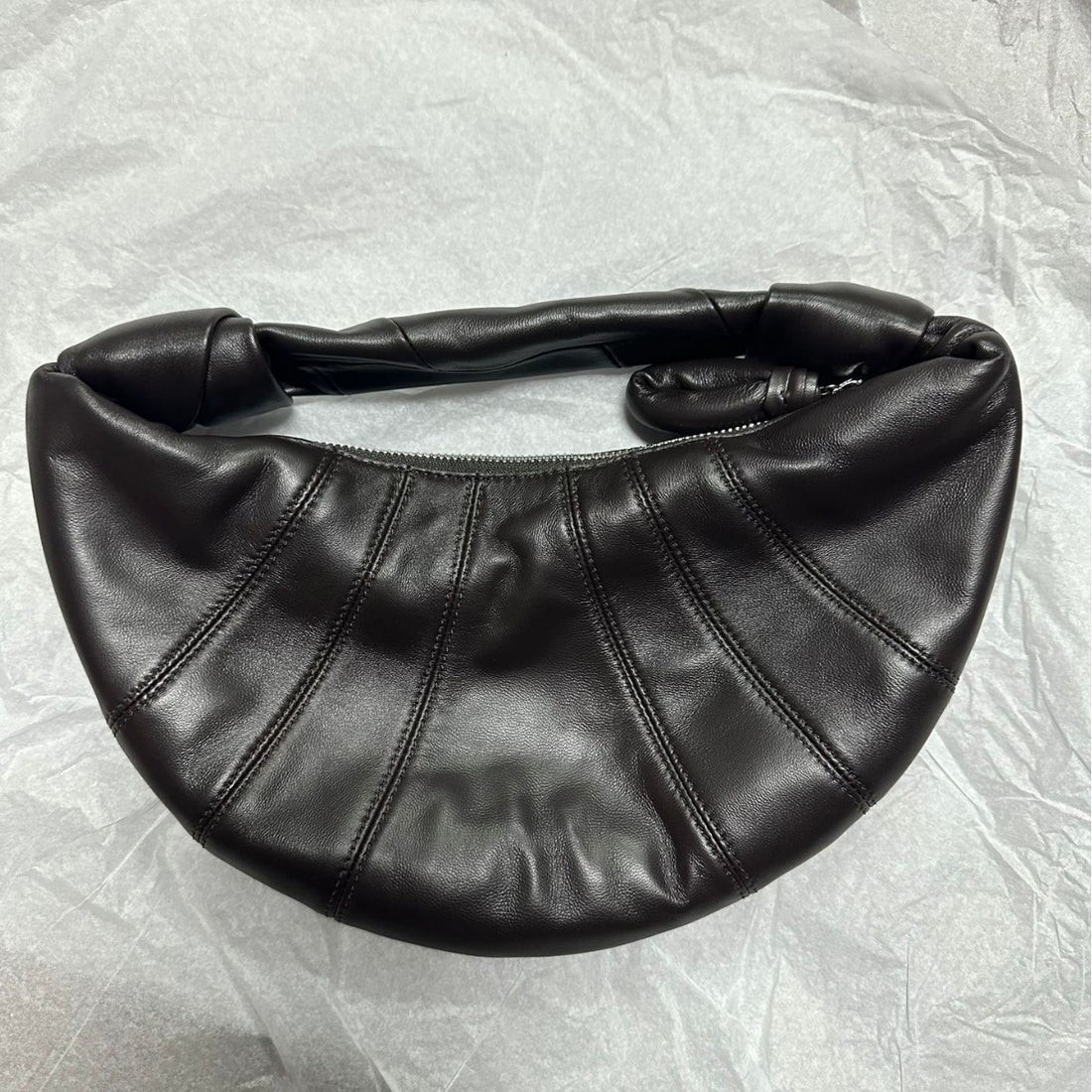 Logo-free lambskin croissant shoulder bag — dark brown front view