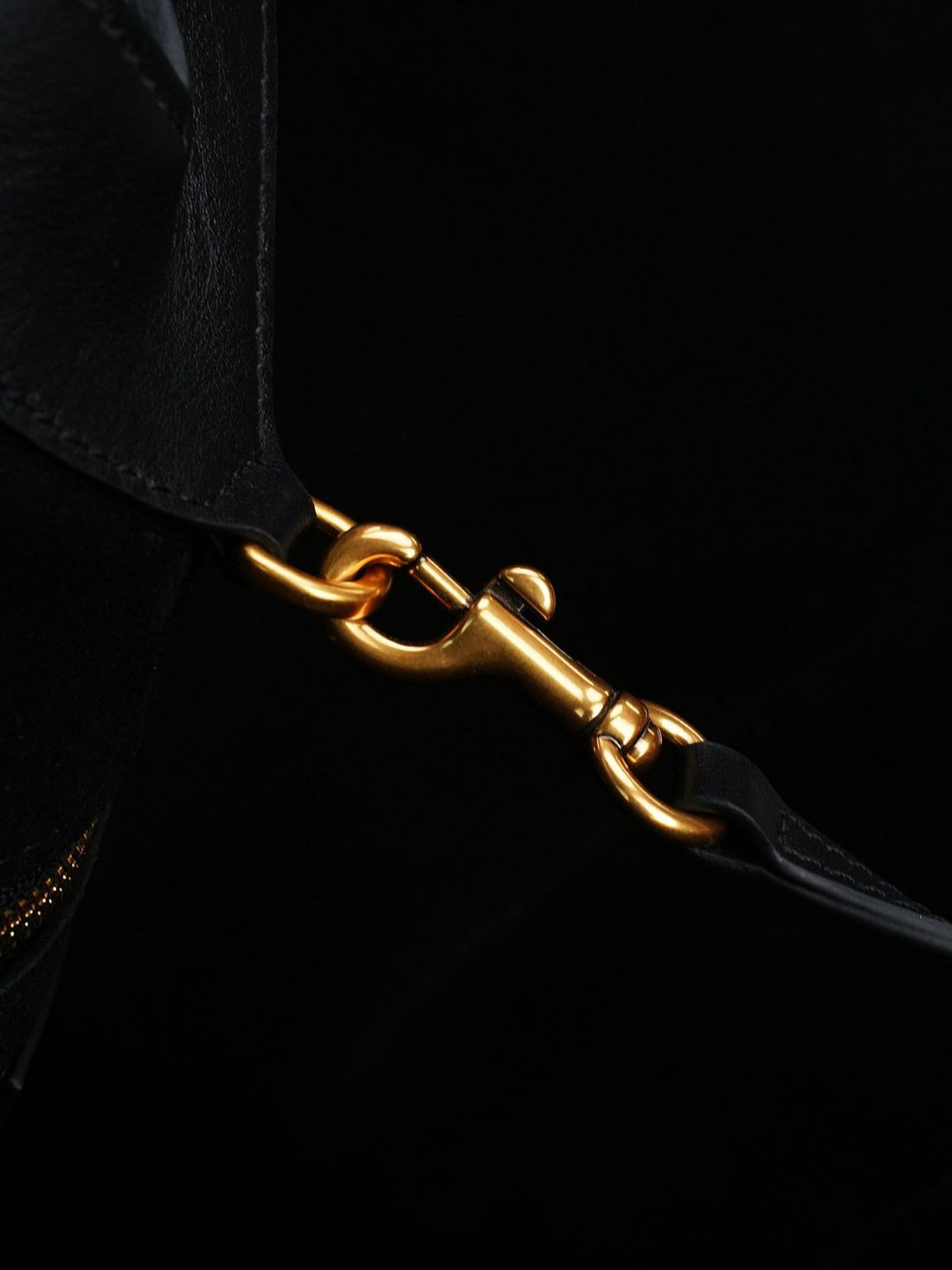Logo-free black Y-strap slouchy leather tote — gold clasp hardware close-up