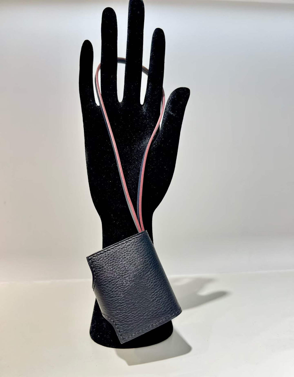 Back view of black hand-stitched leather book bag charm