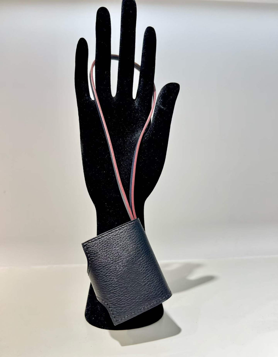 Back view of black hand-stitched leather book bag charm