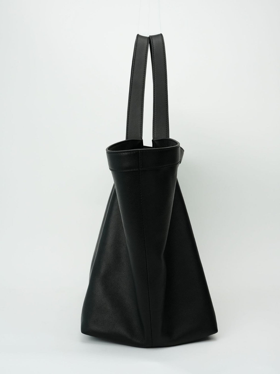 Logo-free black Y-strap slouchy leather tote — side profile