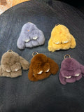 Solid-color fluffy bunny bag charms in gray yellow taupe brown and purple