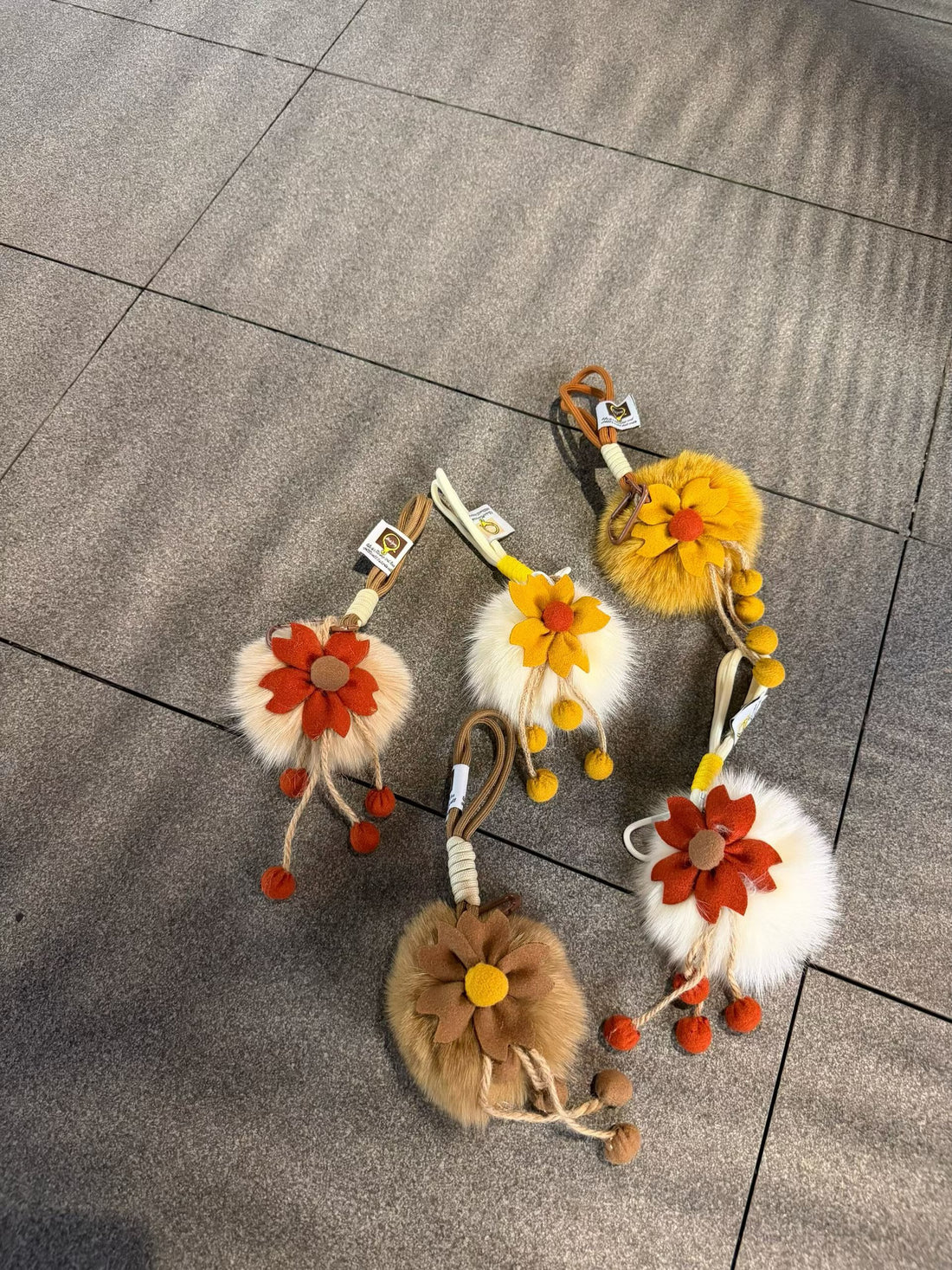 Four fluffy flower bag charm color combinations arranged together