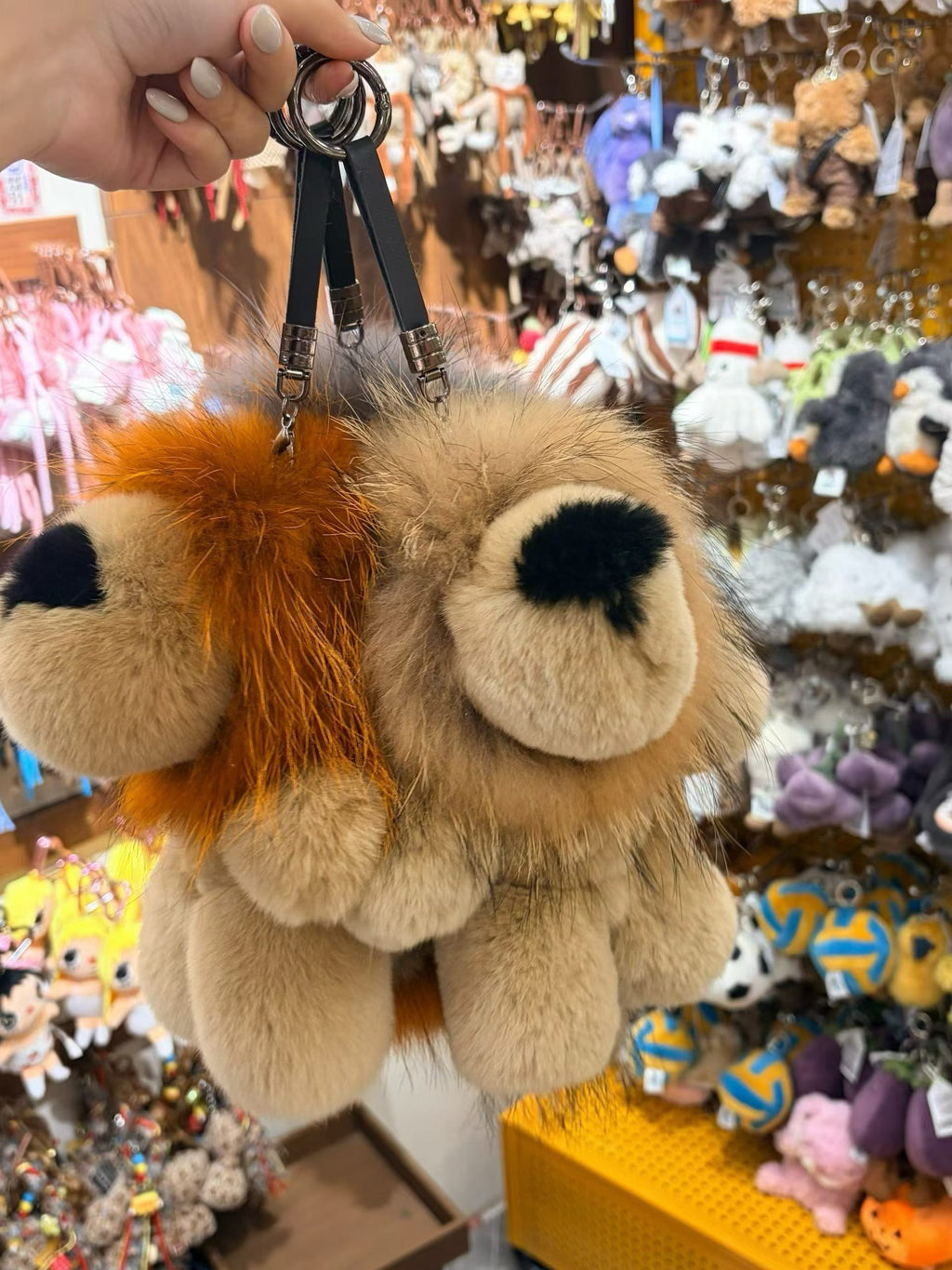 Golden ochre and sand tan fluffy lion bag charms shown together