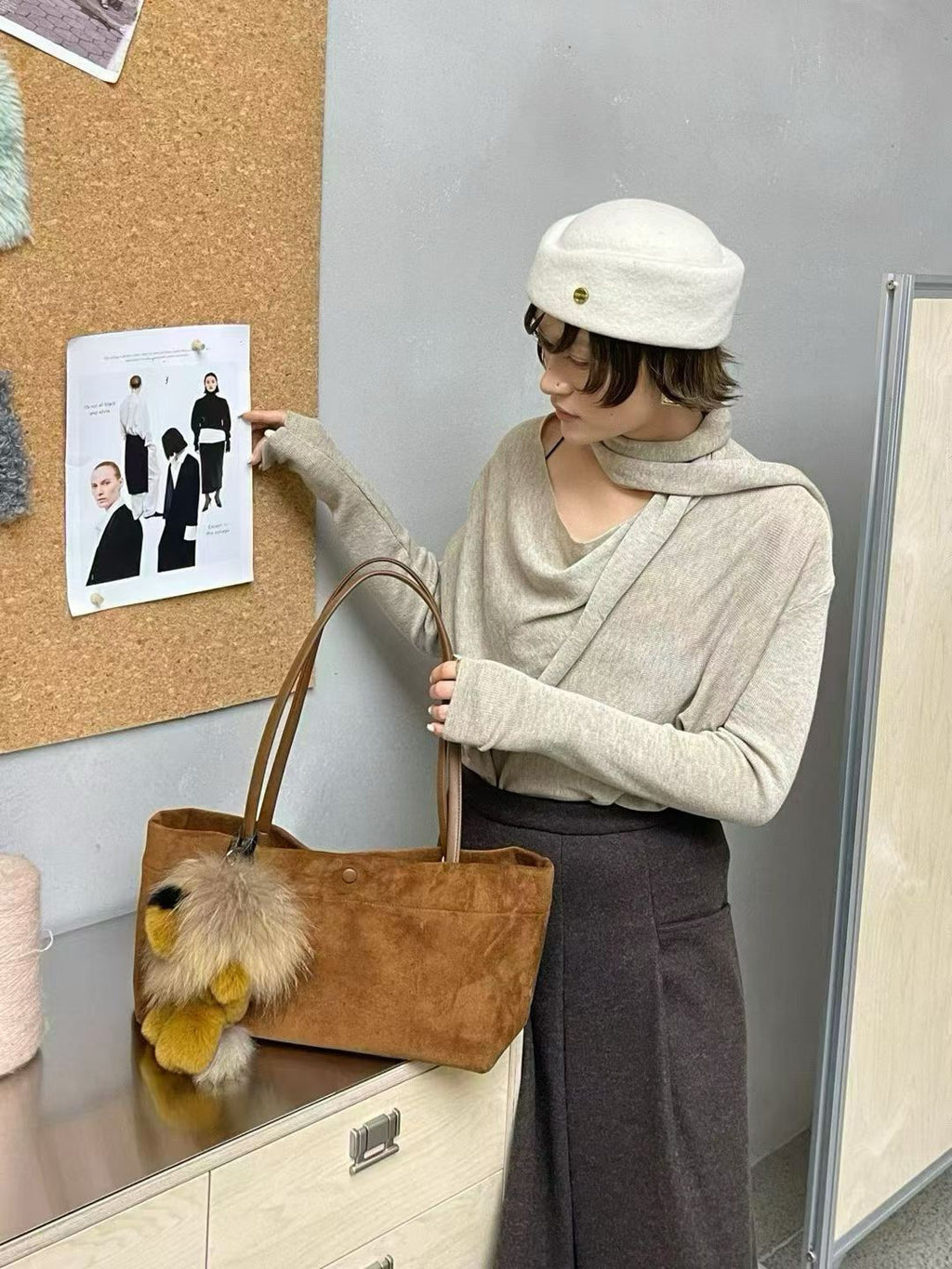 Golden fluffy lion bag charm and brown tote bag styling detail