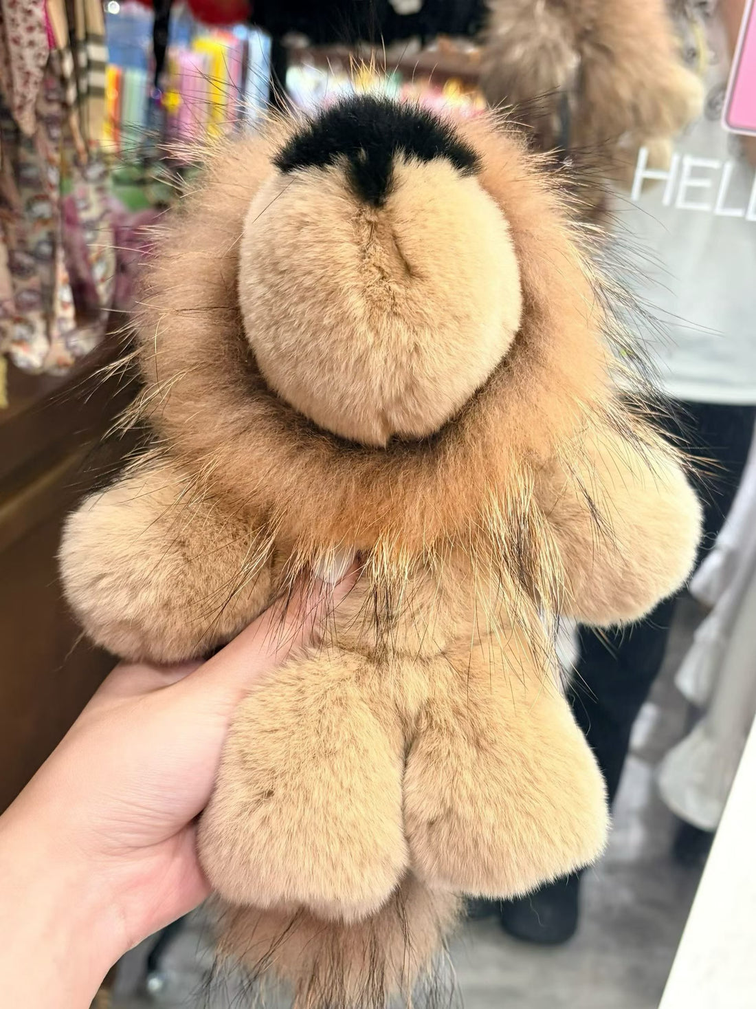 Sand tan fluffy lion bag charm close-up with rounded muzzle and paws