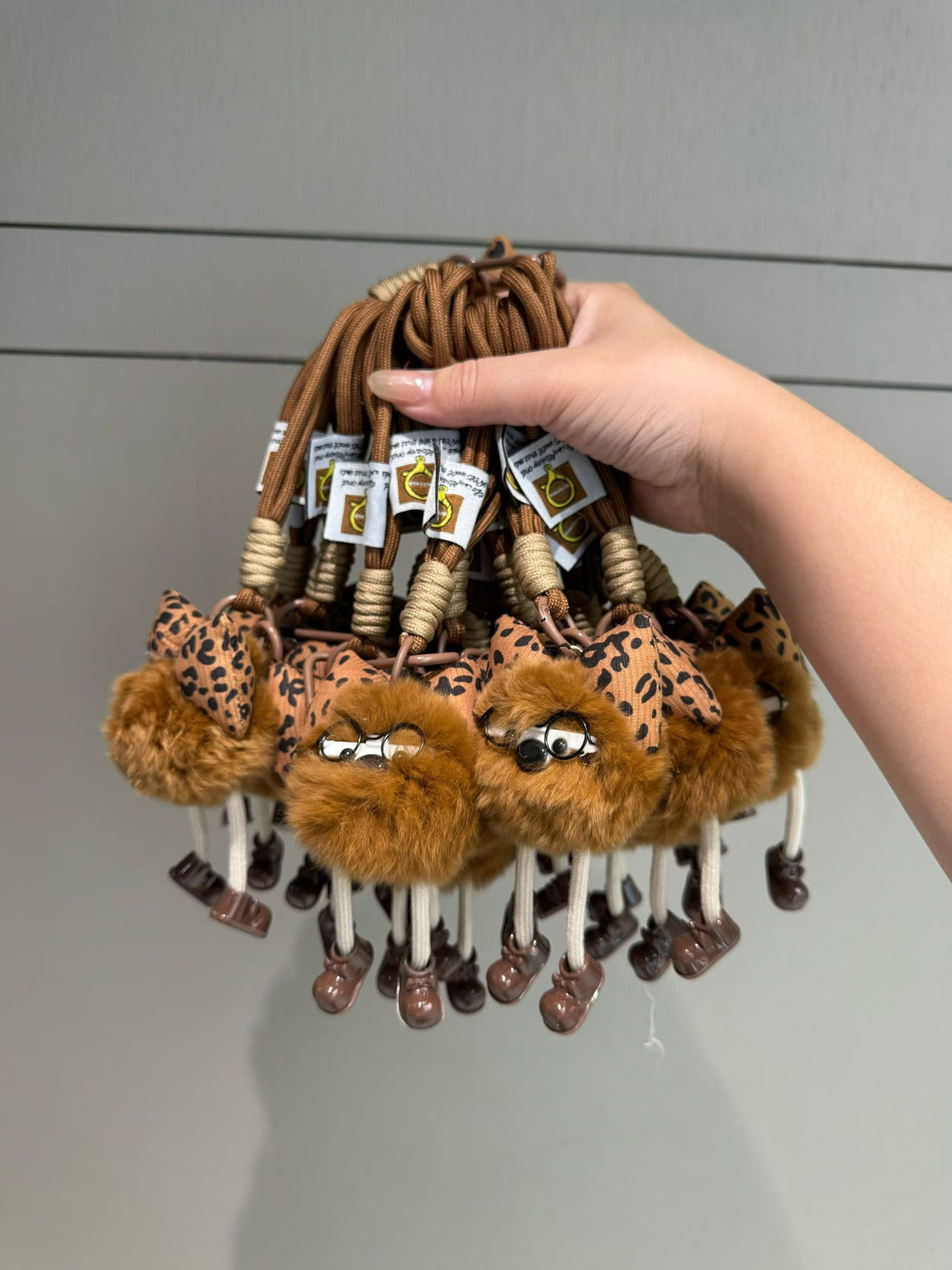 Rust brown fluffy character bag charm with leopard bow glasses and dangling legs