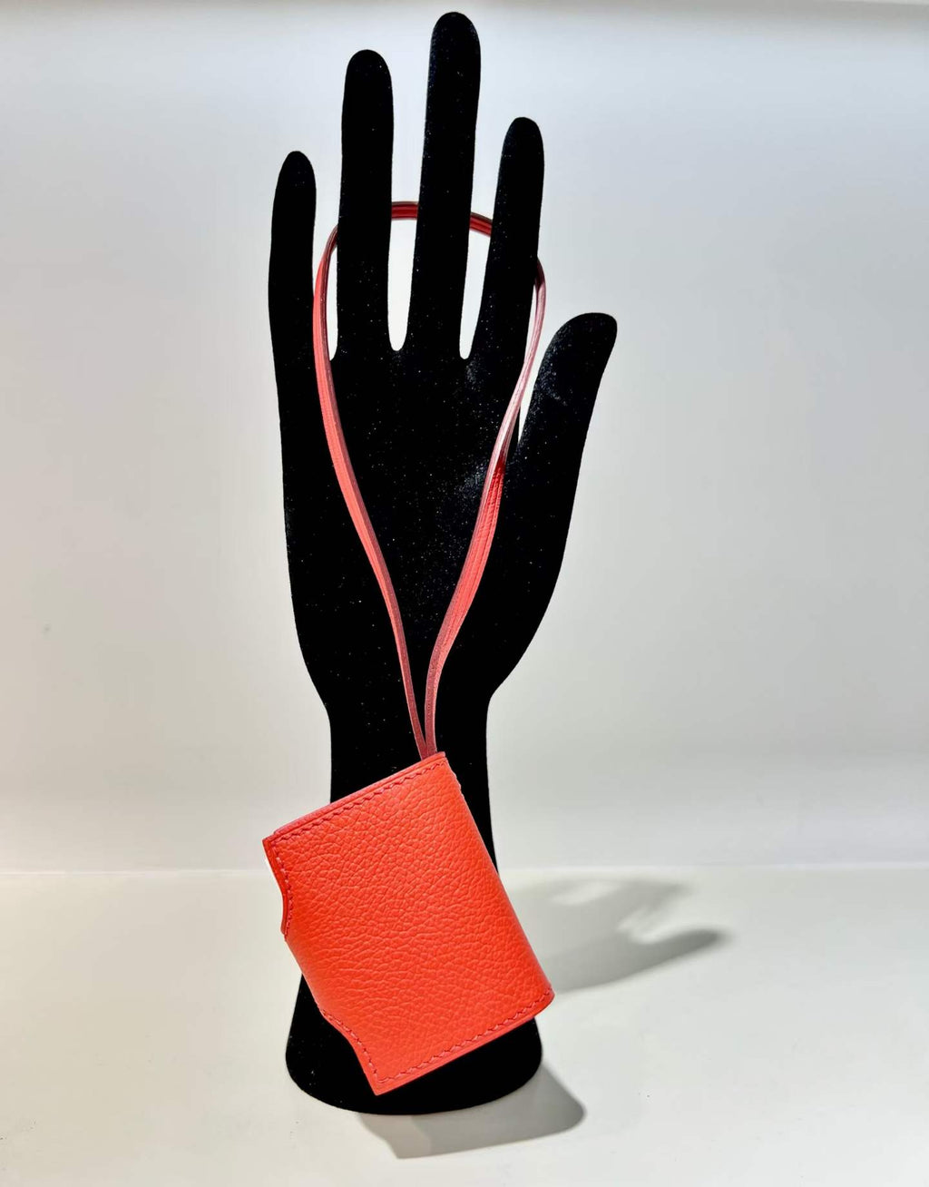 Back view of red hand-stitched leather book bag charm