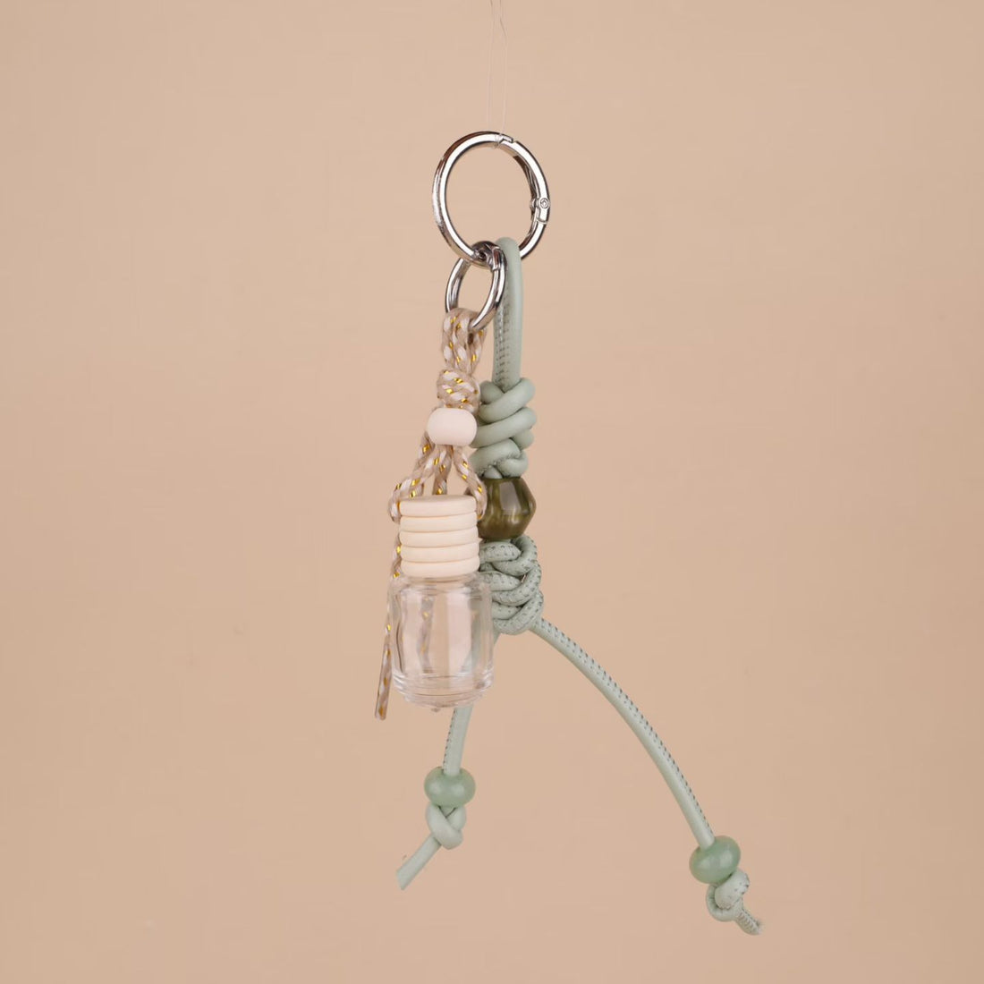 Sage green knotted rope bag charm with mini clear glass bottle