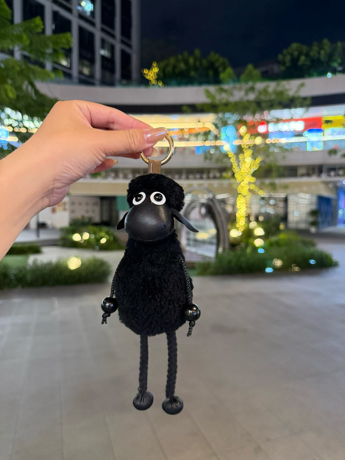 Black fluffy Shaun sheep bag charm with dangling rope legs