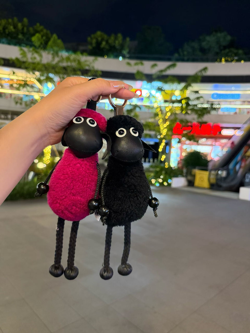 Red and black Shaun sheep handbag charms shown side by side