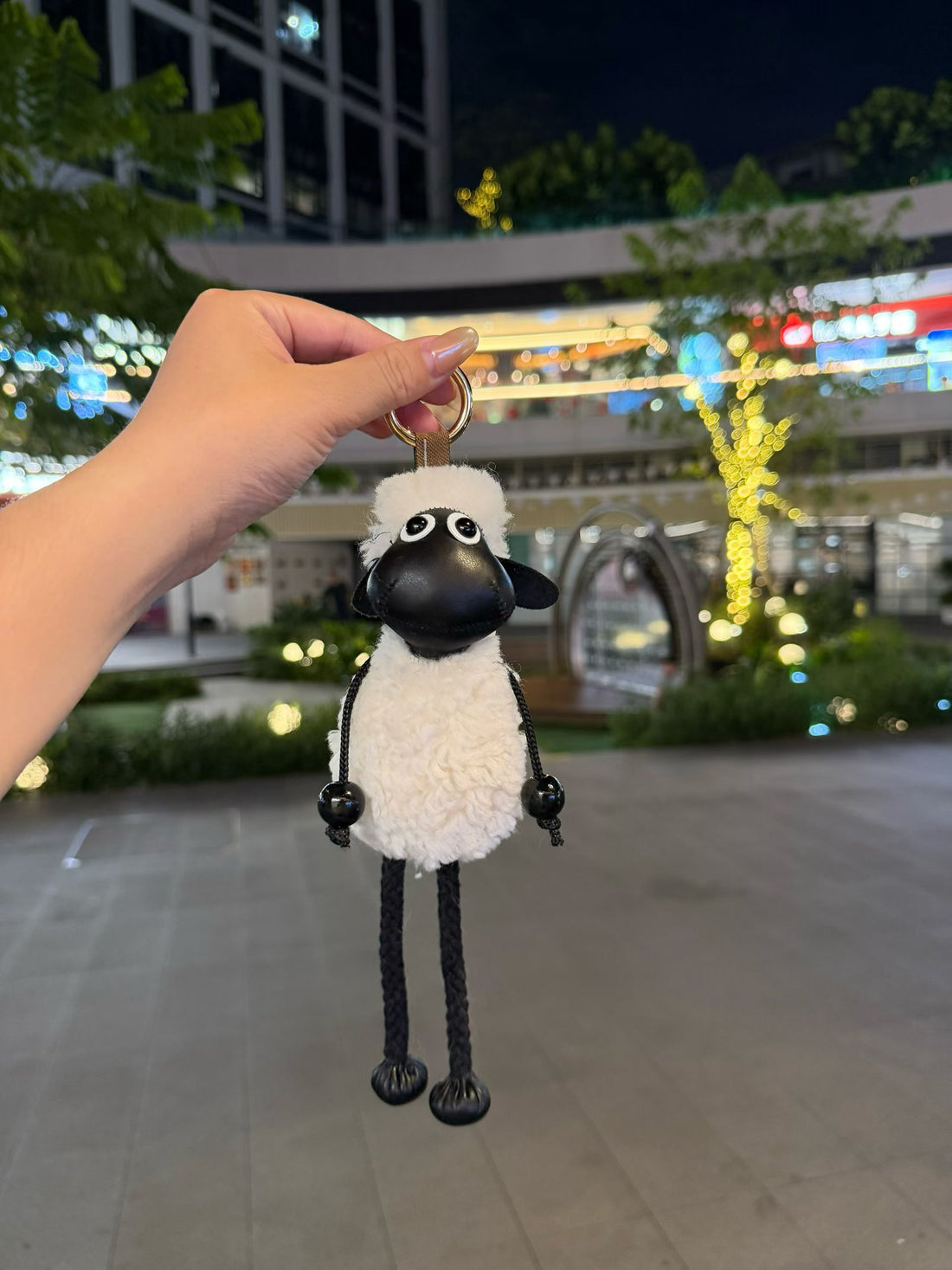 White fluffy Shaun sheep bag charm with black faux leather face