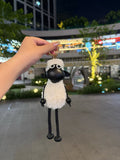 White fluffy Shaun sheep bag charm with black faux leather face