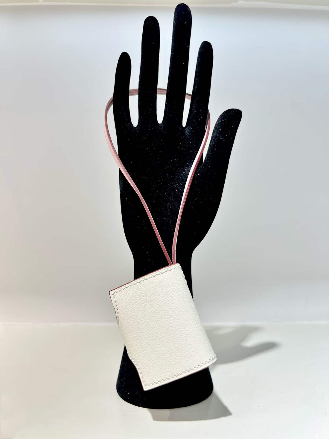 Back view of white hand-stitched leather book bag charm
